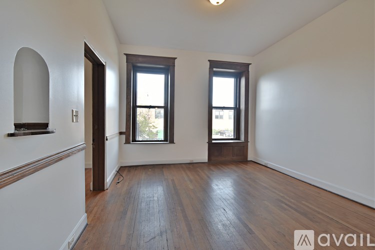 A room with wooden flooring and a white wall.