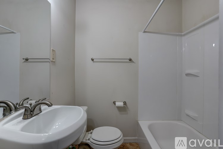 A white bathroom with a sink, toilet and bathtub.