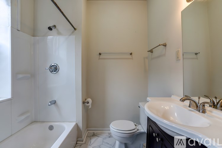A white bathroom with a tub, toilet, and sink.