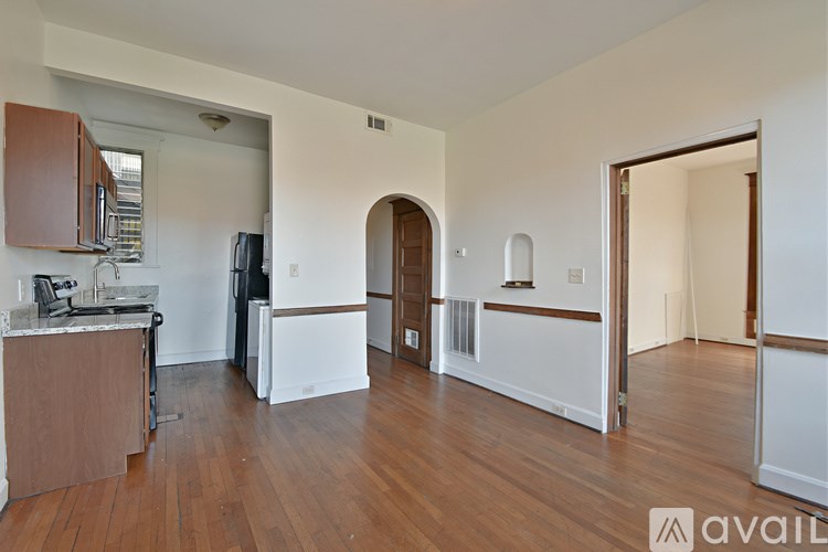 A kitchen area with wooden floors and white walls.