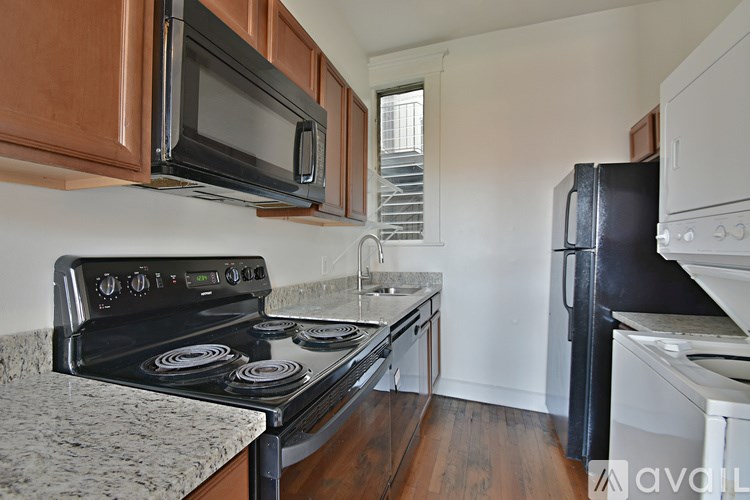 A kitchen with a black stove top oven and a black refrigerator.