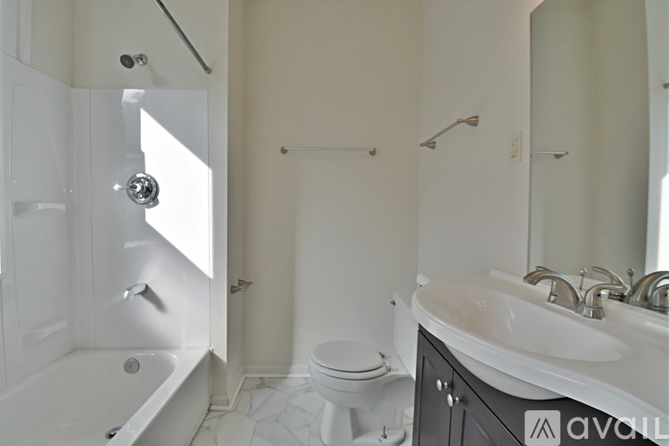 A white bathroom with a tub, toilet, and sink.