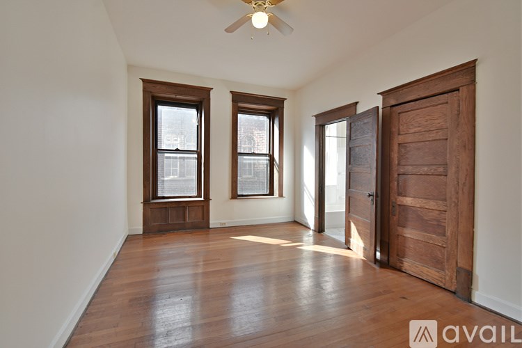A room with wooden floors and a ceiling fan.