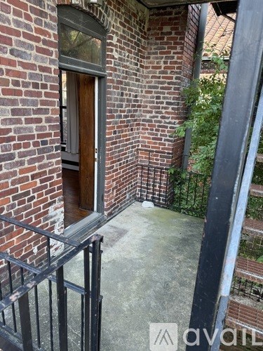 A brick building with a door and a metal railing.