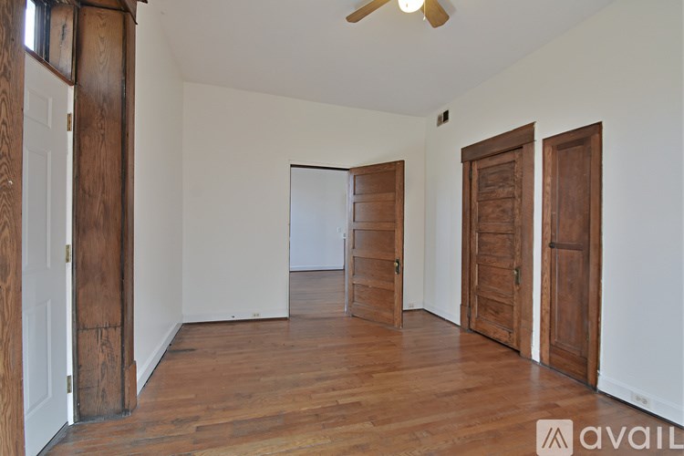 A room with wooden floors and a ceiling fan.