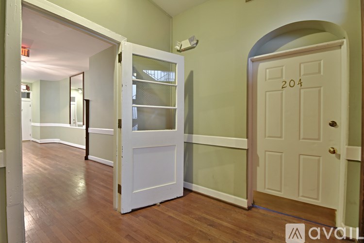 A room with a door numbered 204 and a white door with a glass panel.