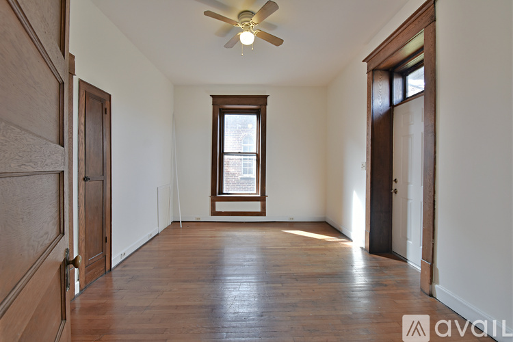 A room with wooden floors and two windows.