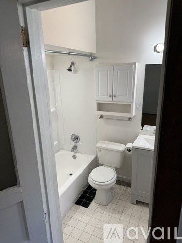 A white bathroom with a toilet, sink and bathtub.