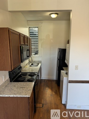 A kitchen with wooden cabinets and a black stove top oven.
