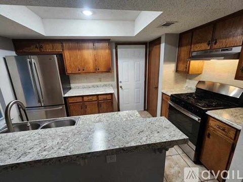 A kitchen with granite countertops and wooden cabinets.