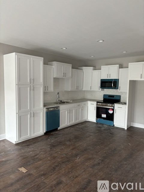A kitchen with white cabinets and a blue dishwasher.