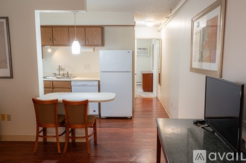 A kitchen with a table and chairs in front of it.
