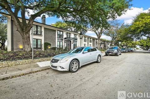 A silver car is parked on a street in front of a building with the Avail logo.