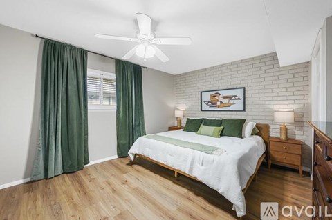 A bedroom with a bed, nightstand, and a ceiling fan.