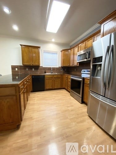 A kitchen with wooden cabinets and stainless steel appliances.