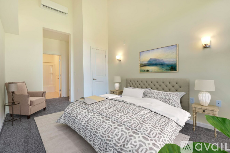 A bedroom with a large bed and a painting on the wall.