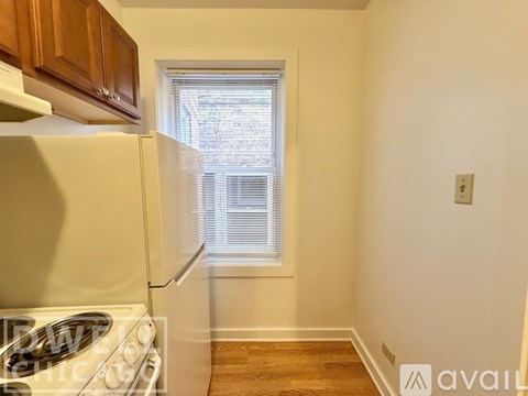 A room with wooden floors and a window showing a brick building outside.
