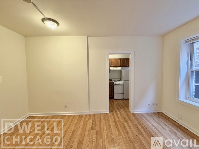 A spacious room with tiled flooring and white walls.