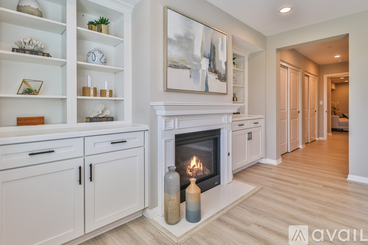 A modern living room with a fireplace and a painting on the wall.