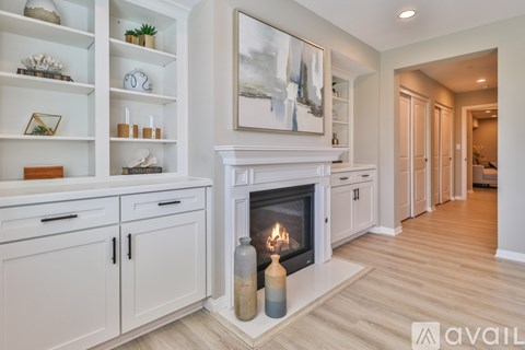 A modern living room with a fireplace and a painting on the wall.