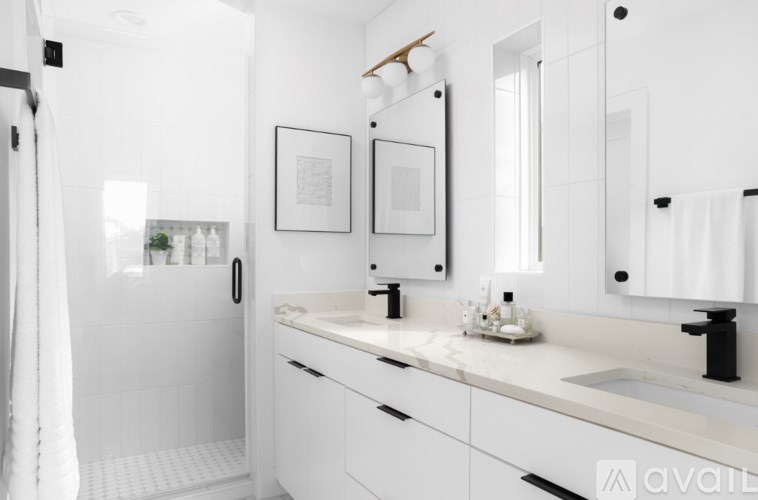 A white bathroom with a sink, mirror, and shower.