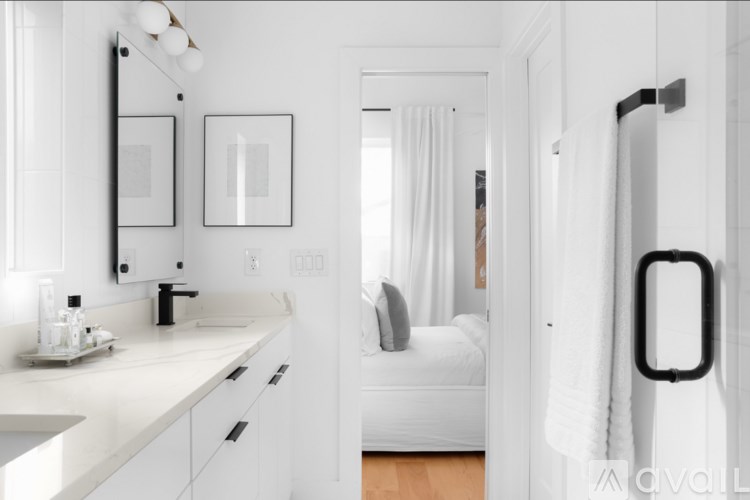 A bathroom with a white theme and a white chair.