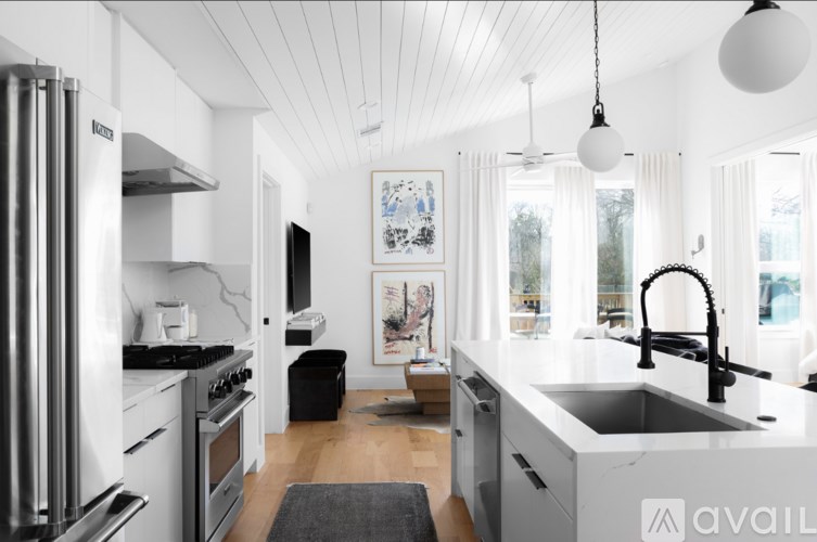 A modern kitchen with a white refrigerator and a black sink.