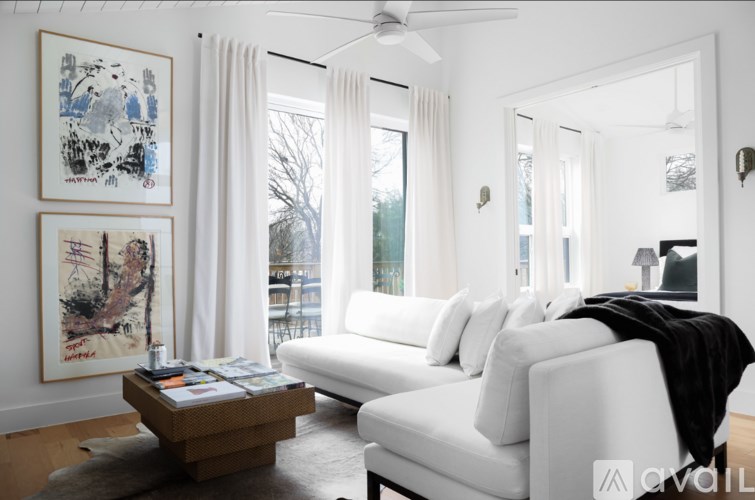 A living room with a white couch, a coffee table, and a ceiling fan.