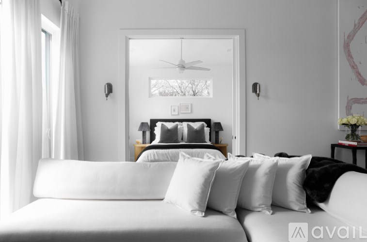 A bedroom with a large bed and a ceiling fan.