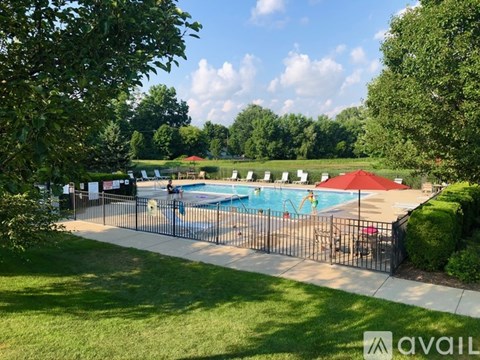 A pool surrounded by a black fence with a sign that says "AVAIL" on it.