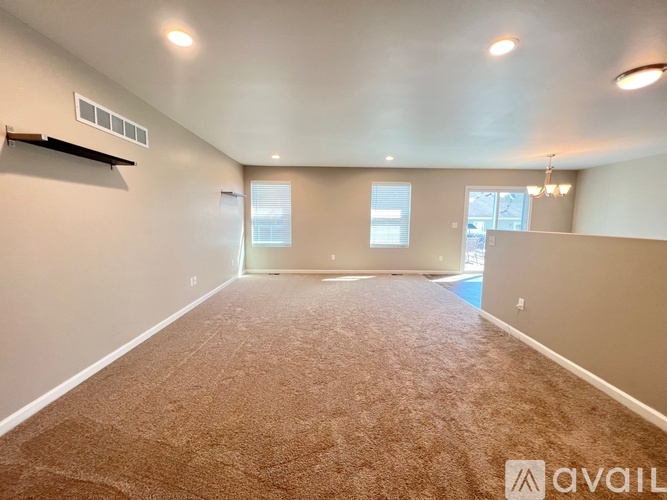 A spacious room with carpeted floor and a window.