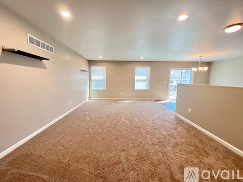 A spacious room with carpeted floor and a window.