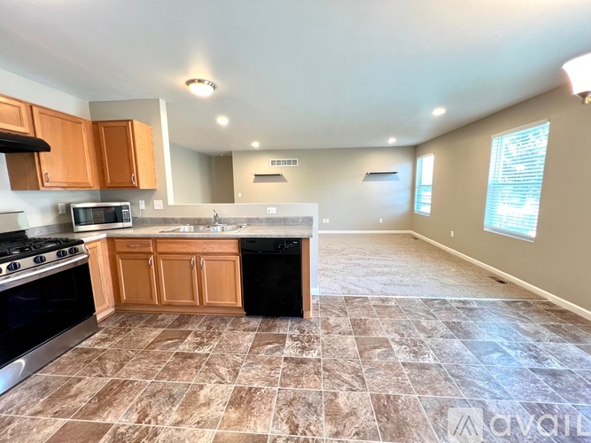 A kitchen with brown cabinets and a tiled floor.