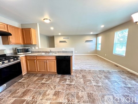 A kitchen with brown cabinets and a tiled floor.