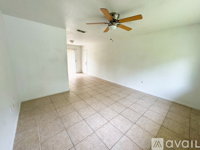A room with a ceiling fan and tiled floor.