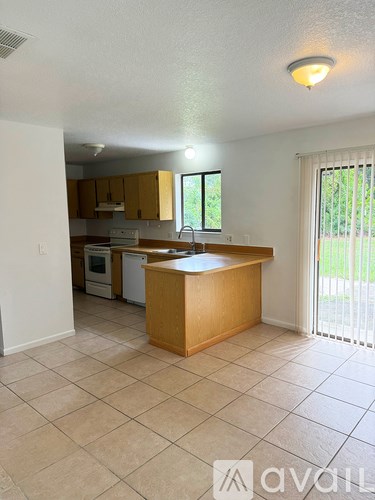 A kitchen with a wooden island and white appliances.