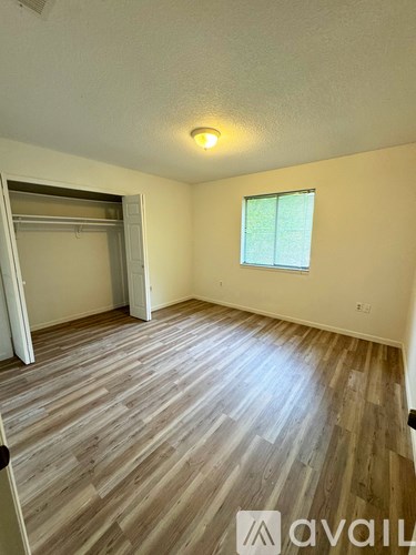 A room with wooden flooring and a window.
