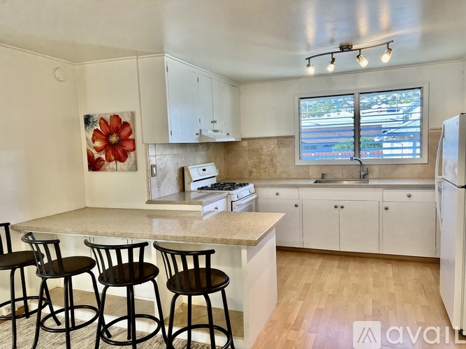A kitchen with white cabinets and a marble countertop.