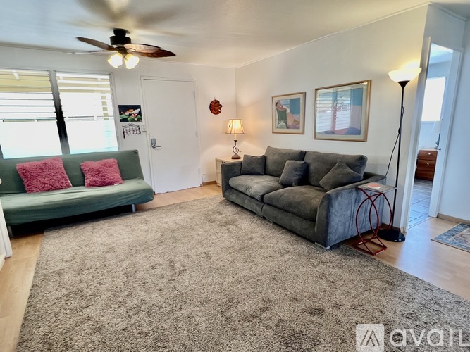 A living room with a green couch and a grey couch.