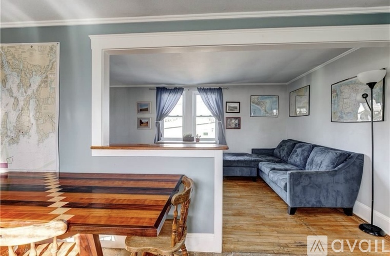 A living room with a wooden table and a blue couch.