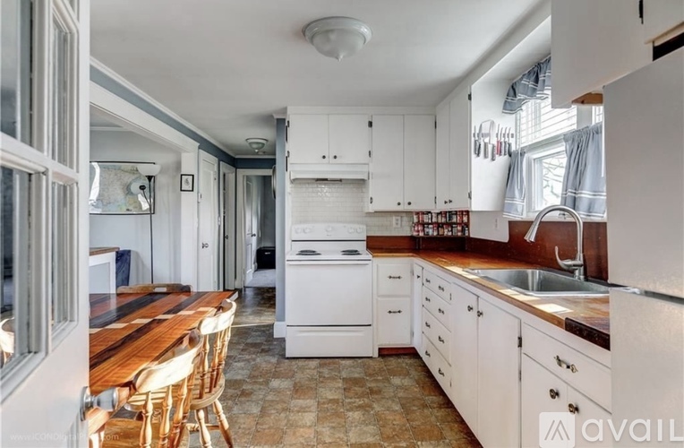 A kitchen with white appliances and wooden countertops.