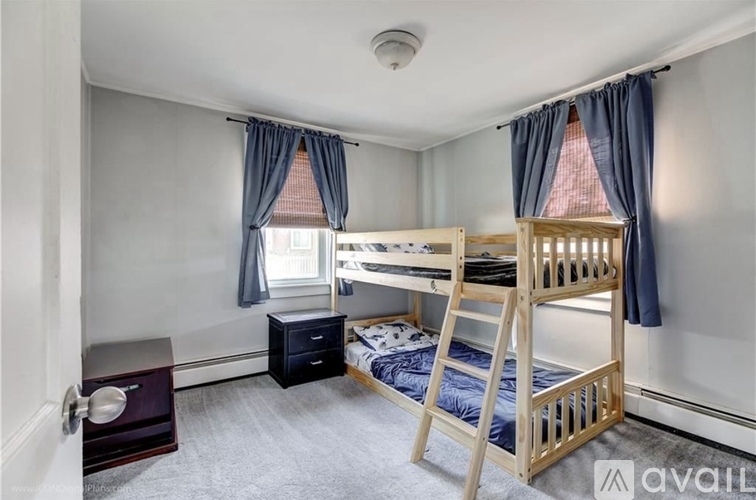 A bedroom with a bunk bed and a nightstand.