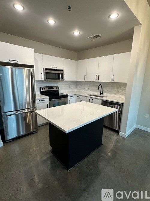 A kitchen with a white countertop and stainless steel appliances.