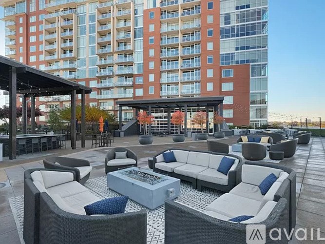 A patio area with white furniture and a building in the background.