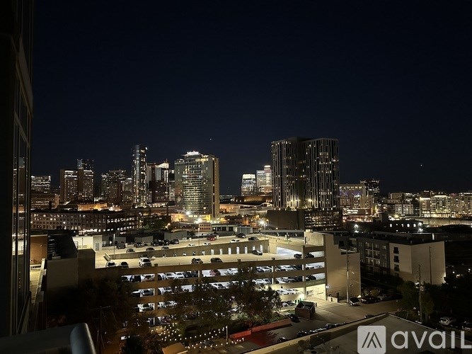 A room with a ceiling fan and large windows overlooking a city.
