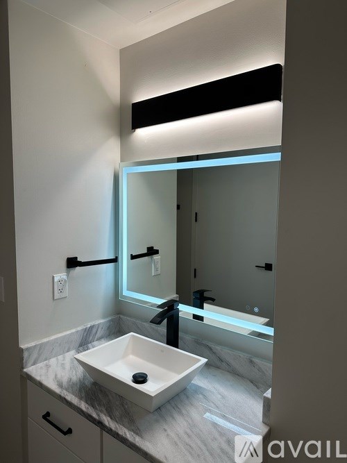A bathroom with a marble countertop and a rectangular sink.