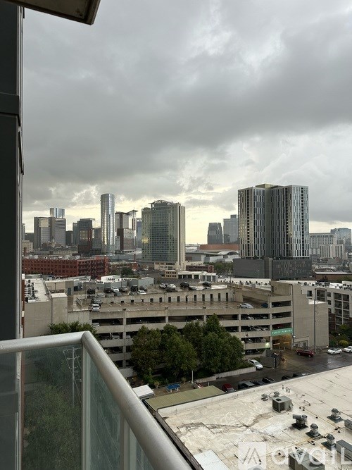 A cityscape with tall buildings and a cloudy sky.