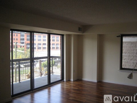 A room with a view of a balcony and a building outside.