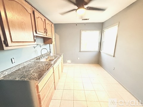 A kitchen with wooden cabinets and a marble countertop.