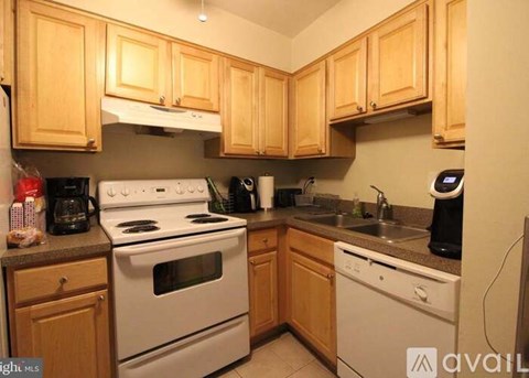 A kitchen with wooden cabinets and white appliances.